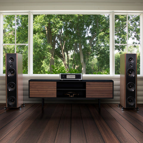 PSB Synchrony T800 Tower Speakers in front of a window, with a credenza in between them that features an NAD M33