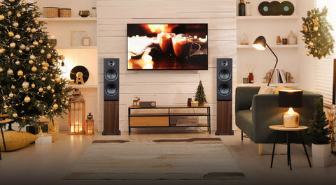 Modern living room with Christmas tree, TV, psb alpha t20 speakers, and decorative items.