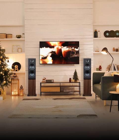 Modern living room with Christmas tree, TV, psb alpha t20 speakers, and decorative items.